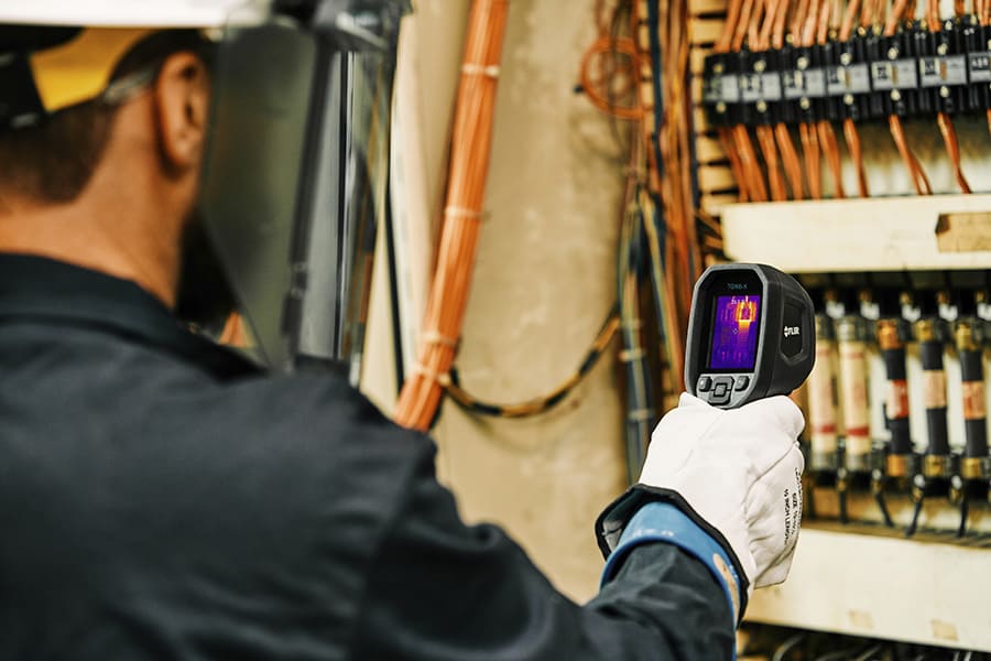 Person using a TG165-X thermal imaging camera in an electrical wirings