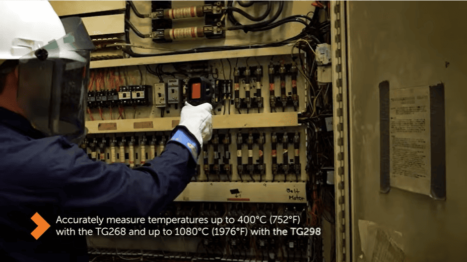 Person working on an electrical panel using a FLIR TG268 with text about temperature measurement capabilities.