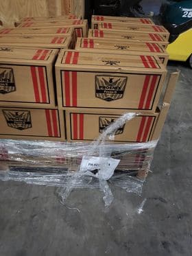 Stack of cardboard boxes with a visible brand logo for Phoenix on a concrete floor.