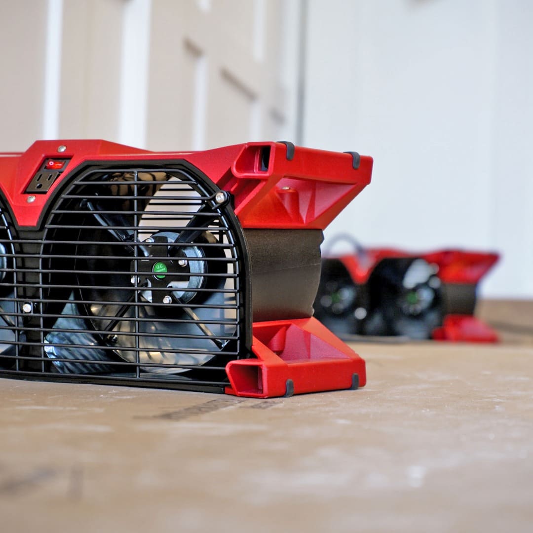 Phoenix Focus II Dual Axial Air Mover on a wooden surface with a blurred background