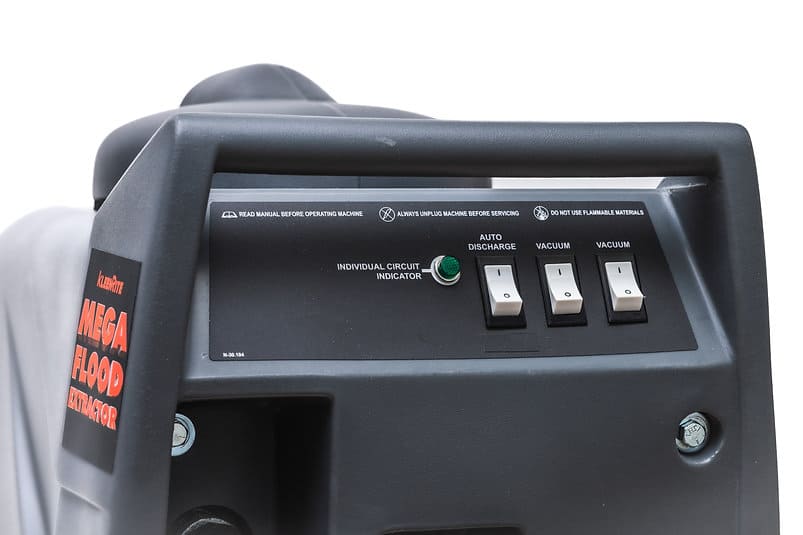 Control panel of a Mega Flood Extractor machine with switches and indicators.