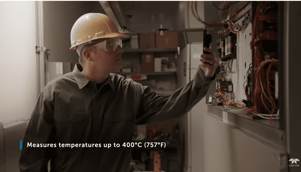 Person in a hard hat using a FLIR ONE Edge Pro thermal camera in an industrial setting with text about temperature measurement.