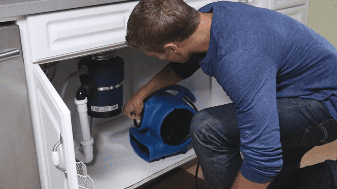 XPOWER X-830 1 HP Air Mover Man putting the air mover under the sink