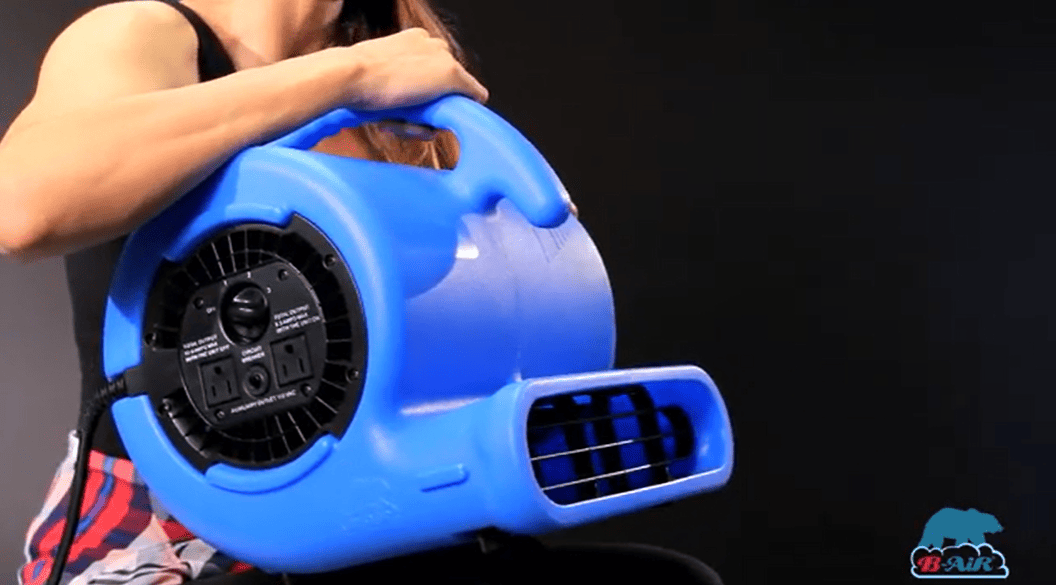 B-Air_VP-25_a woman holding the bair vp25 air mover with a logo on the side