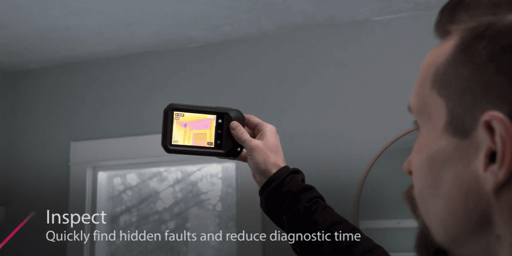 Person using a c5 camera thermal imaging device to inspect a wall