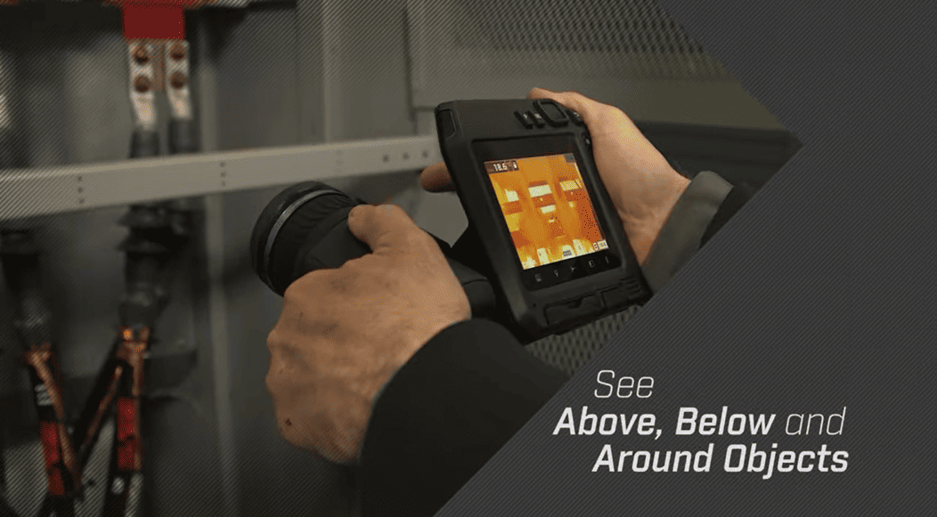 Person holding a flir t530, with a dark background.