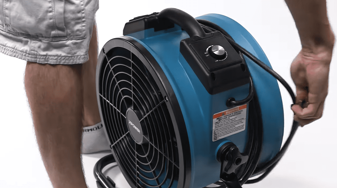 Blue industrial 35AR fan held by a person on a white background