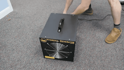 Titan 2000 Hydroxyl generator on a carpeted floor with a person partially visible. 