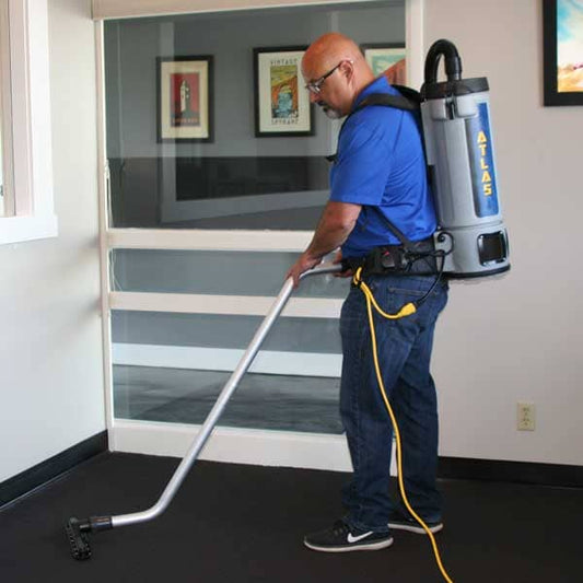 Contractor using commercial backpack vacuum on carpet