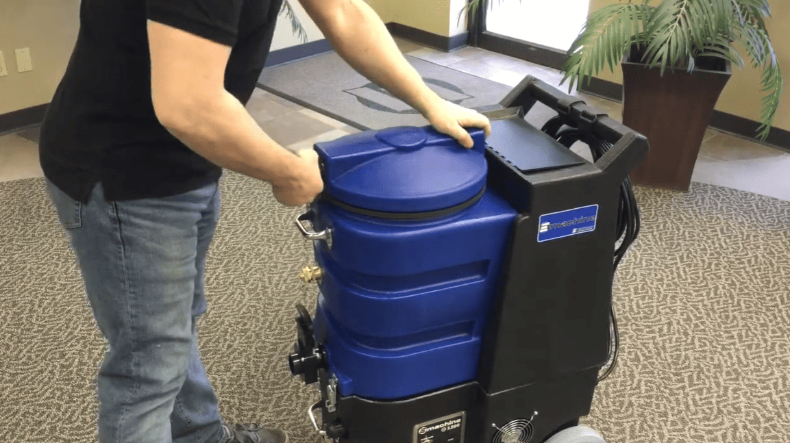 Person pushing a large blue and black E1200 Hard Surface Cleaner in an indoor setting