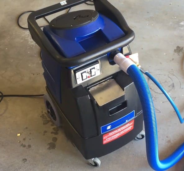 Blue and black E600 machine with a hose on a concrete floor