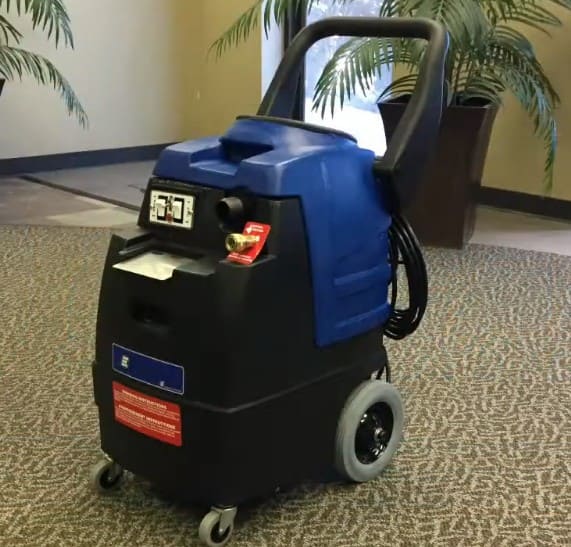 EsteamE600 extractor machine on a carpeted floor with plants in the background.
