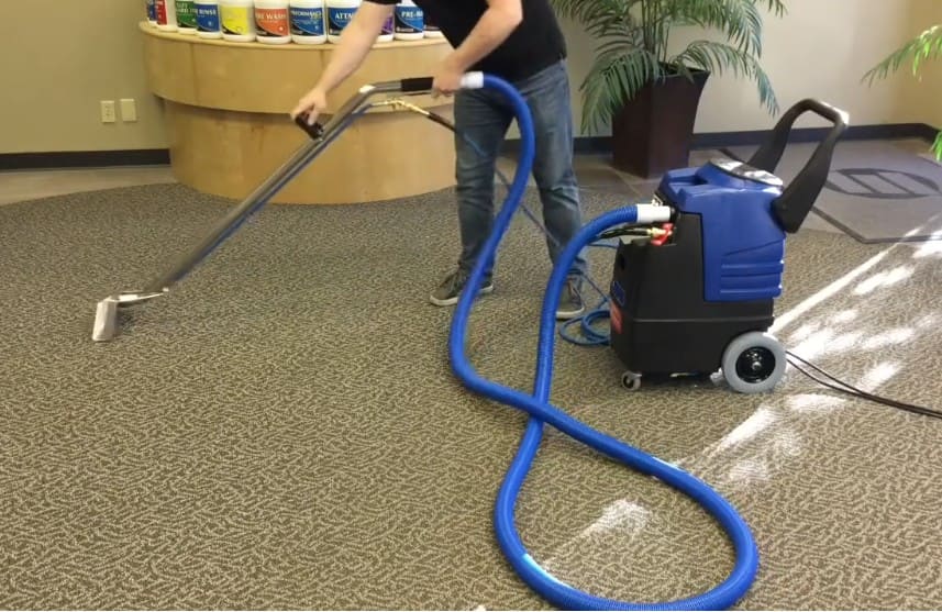 Person using a Esteam E600 carpet cleaning machine on a carpeted floor
