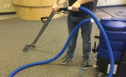 Person using a Flood master carpet cleaning machine on a carpeted floor