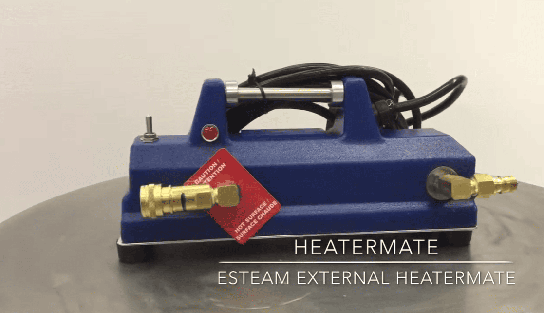 Blue external heatermate with brass connectors on a gray surface, featuring a red tag.
