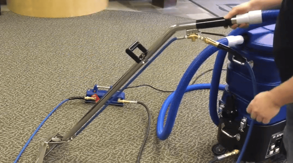 External Heatermate Person using a carpet cleaning machine on a carpeted floor