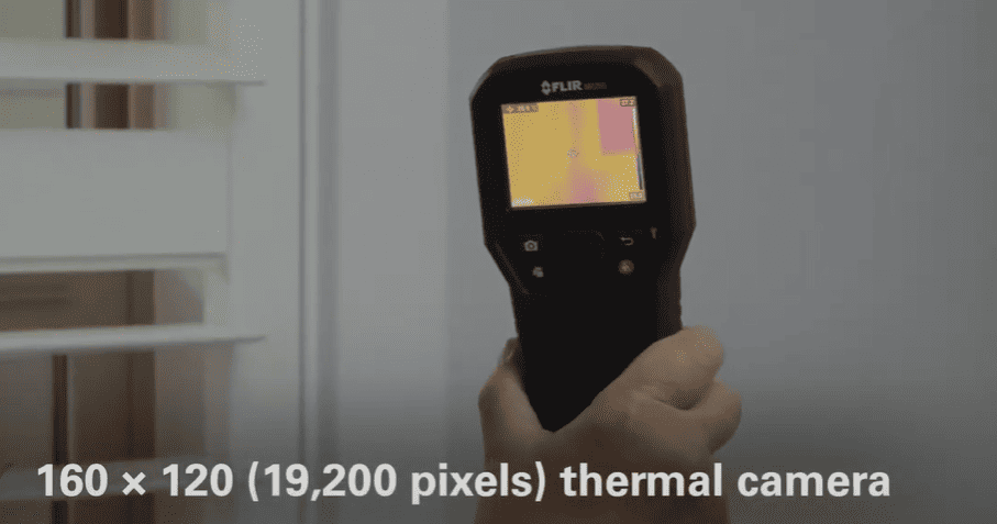 MR265 Hand holding a thermal imaging camera with a blurred background