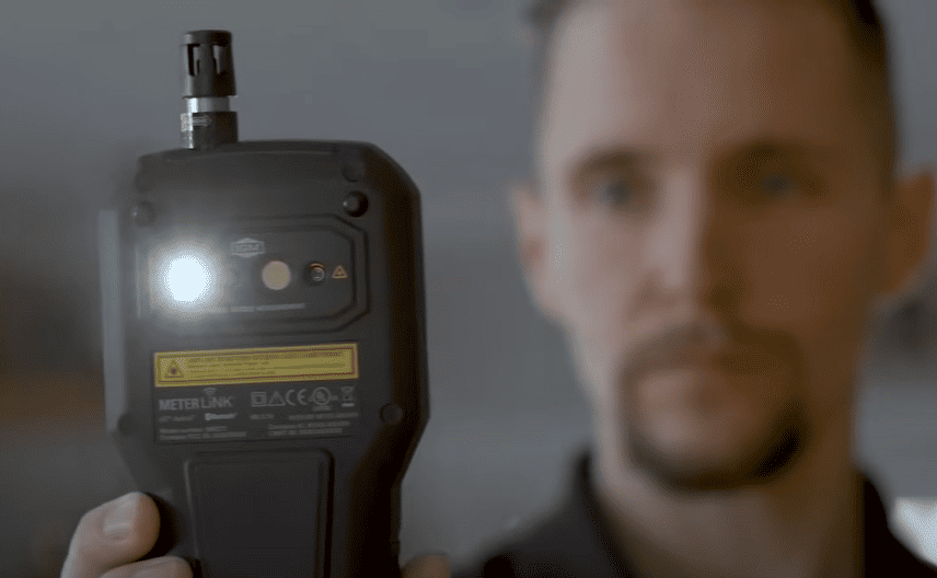 A person holding a MR277 with a light  on, blurred background