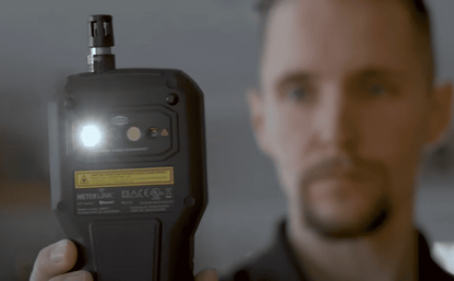 A person holding a MR277 with a light  on, blurred background