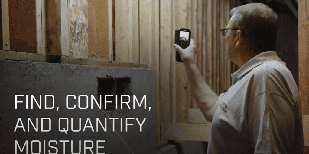 Person using a Flir MR265 to check moisture levels in a building's wooden structure.