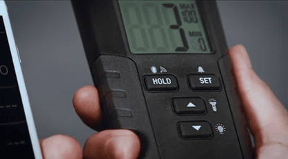 Digital Flir MR59 Moisture meter being held by a person with a blurred background