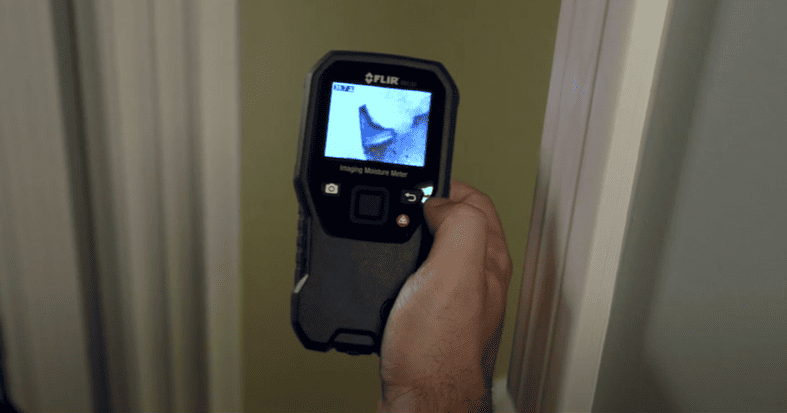 MR160 hand holding a thermal imaging device against a wall.