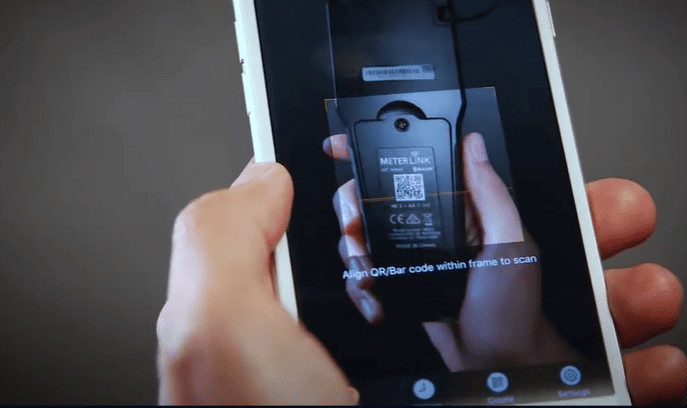 Hand holding a smartphone with a QR code scanner app open on a dark background Moisture Meter MR55 