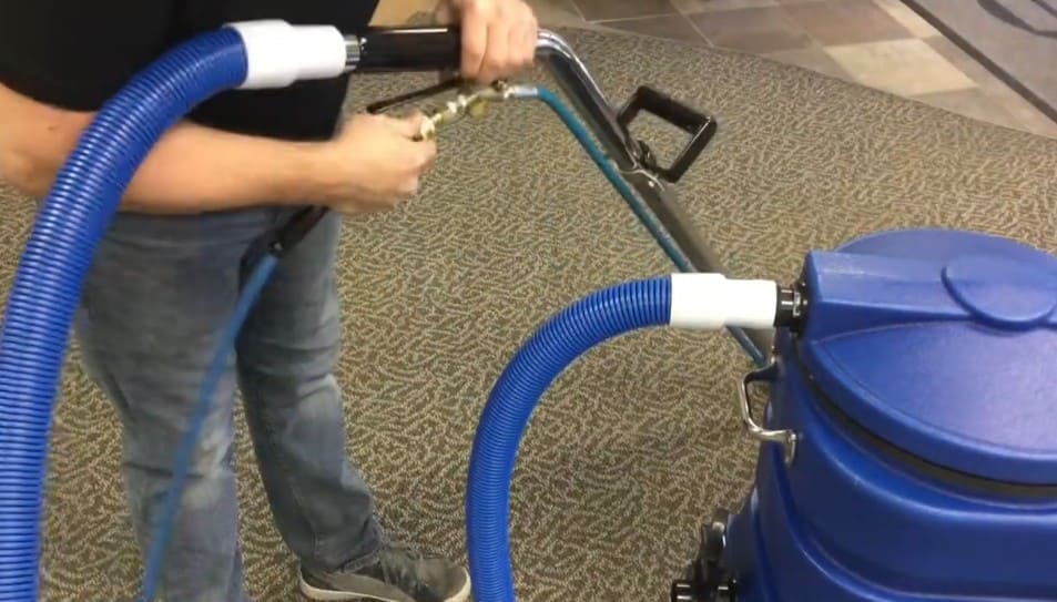 Person using a ninja 150 carpet extractor on a carpeted floor