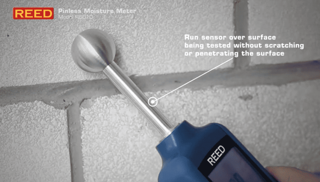 REED R6010 moisture meter being used on a concrete surface