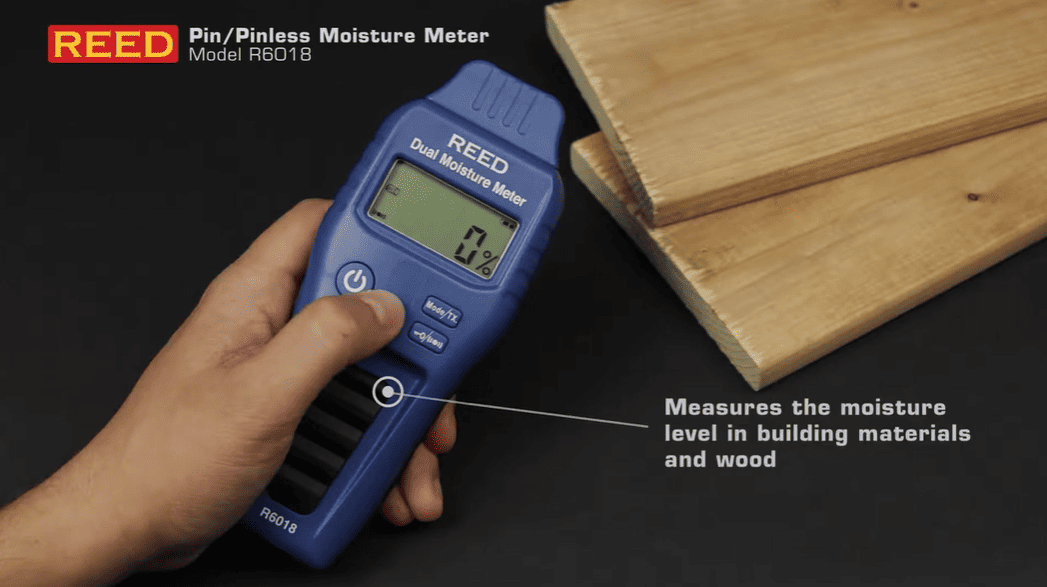 REED pinless moisture meter being held over wooden planks with text indicating its use.