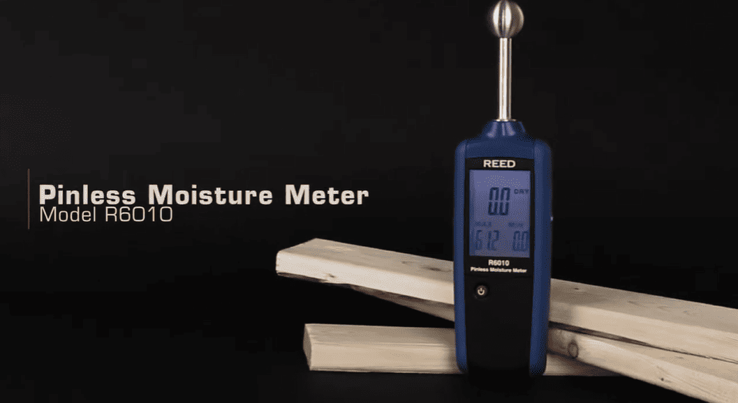 Pinless Moisture Meter Model R6010 on a wooden block with a dark background