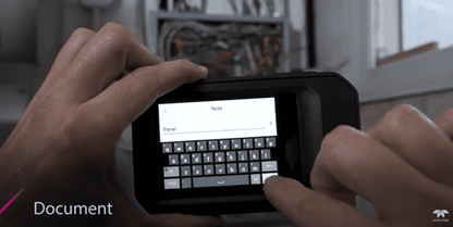 Person using a flir c5 digital Thermal camera device with a keyboard interface in an indoor setting.