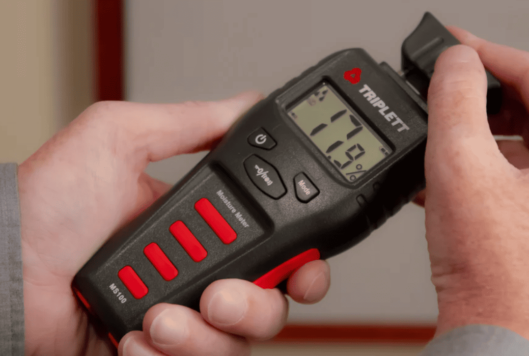 Man Holding a Triplett MS150 Pin & Pinless Moisture Meter