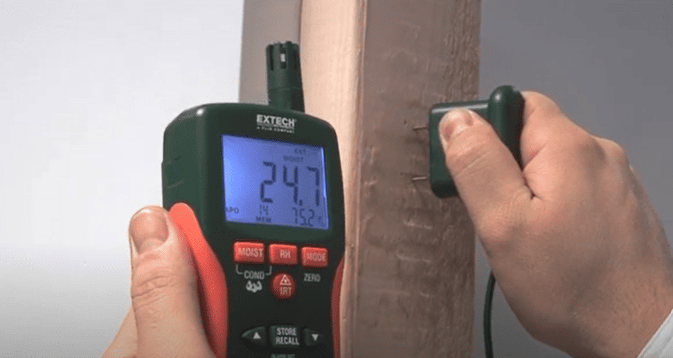 Person using a Extech mo290 moisture meter on a wooden surface