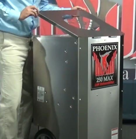 Person interacting with a phoenix 250 max dehumidifier machine in an indoor setting