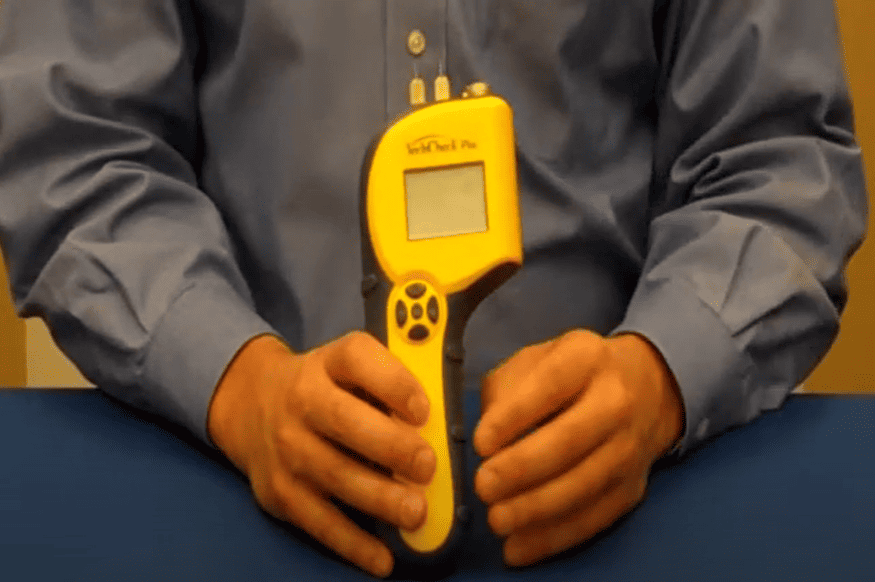 Person holding a techcheck_plus on a blue surface